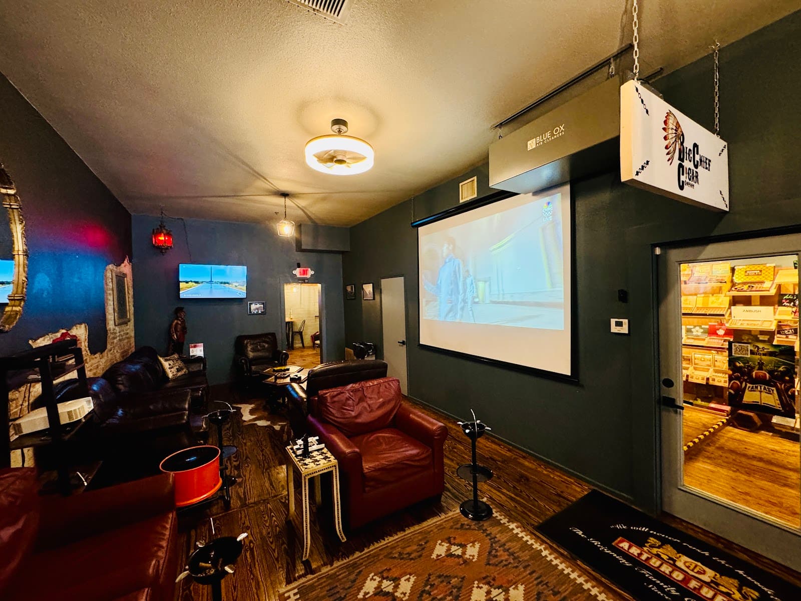The Big Chief lounge, with leather chairs, the hanging Big Chief sign, and the doorway into the humidor