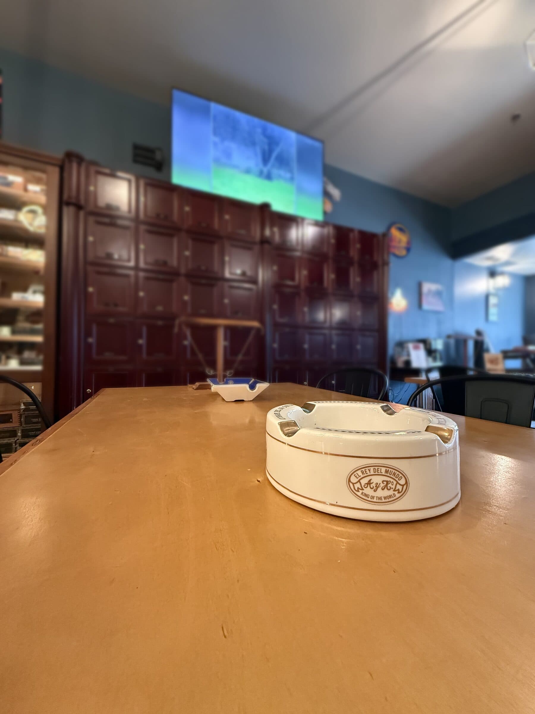 An El Rey del Mundo ashtray on a lounge table, with the locker wall behind it