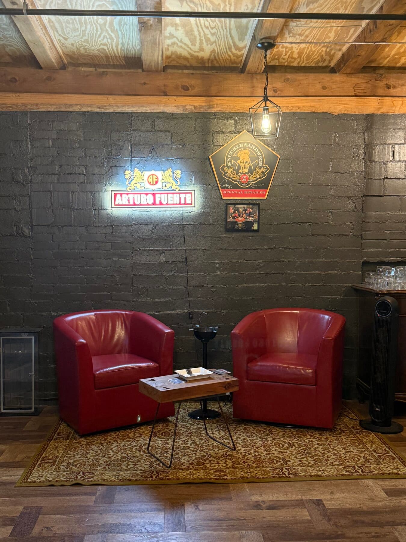Two red club chairs under warm light inside Big Chief Cigar Company