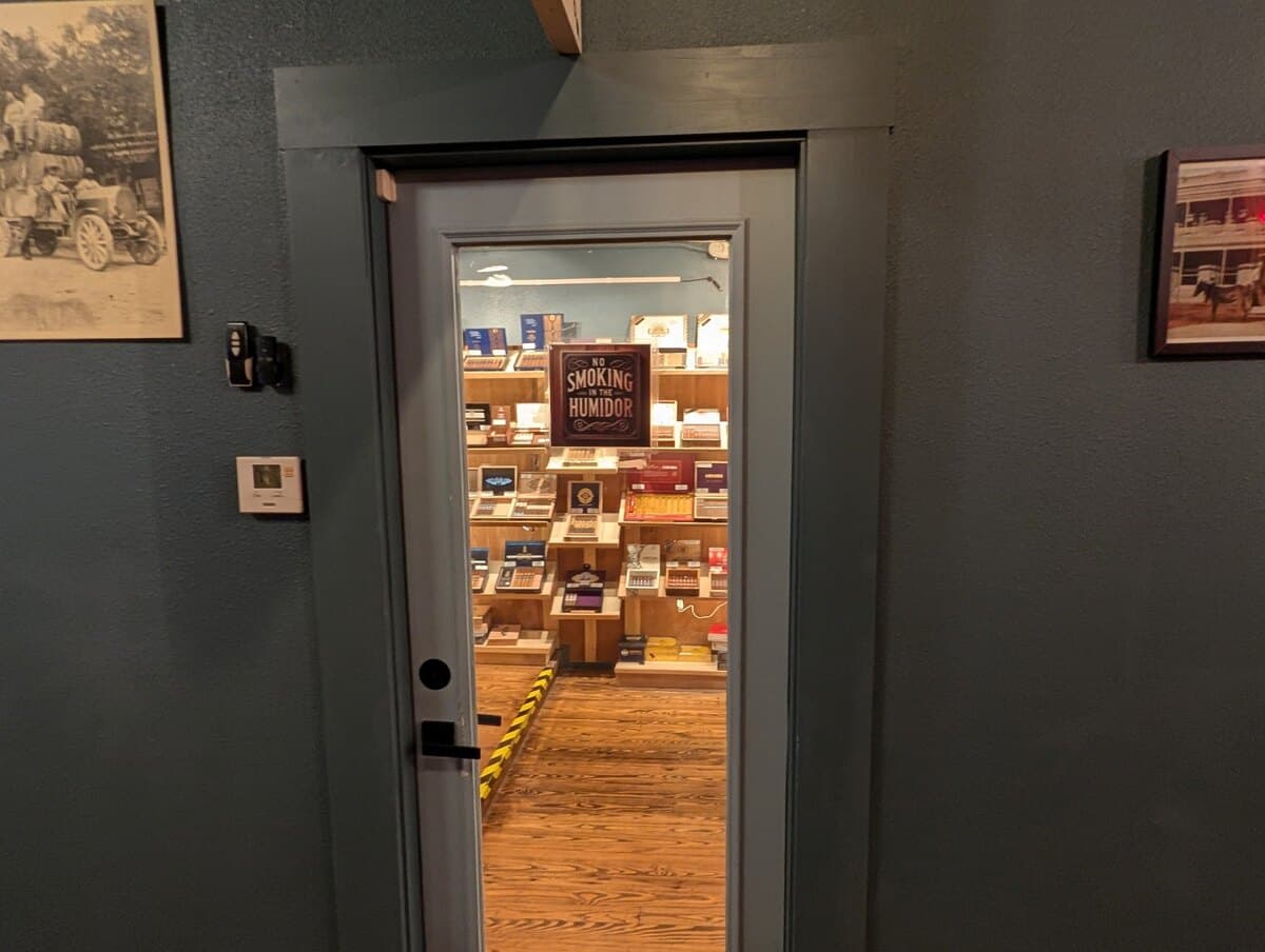 The glass door into the walk-in humidor, with a No Smoking in the Humidor sign