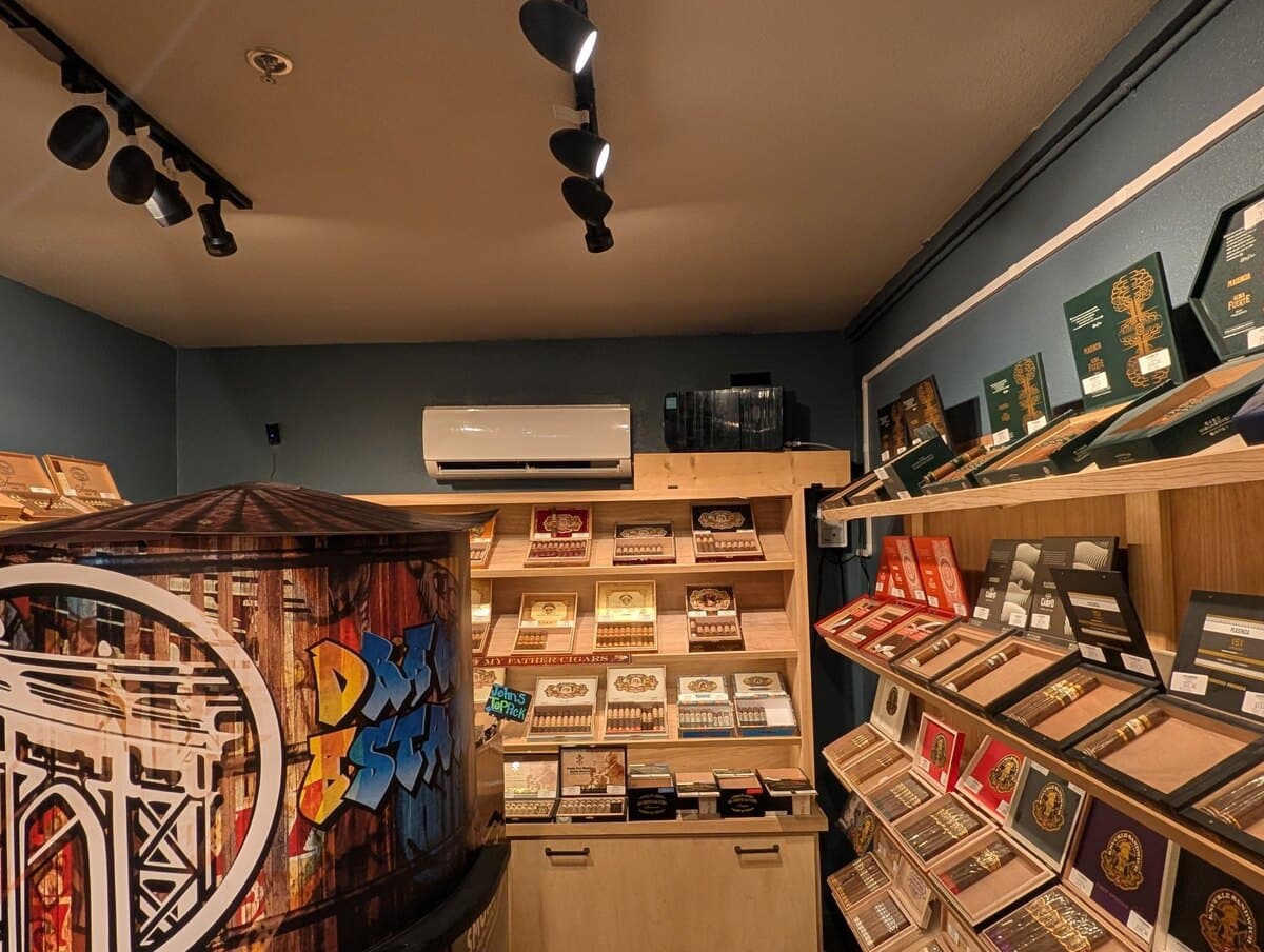 Inside the walk-in humidor: lit shelves of open cigar boxes and a display painted like a water tower